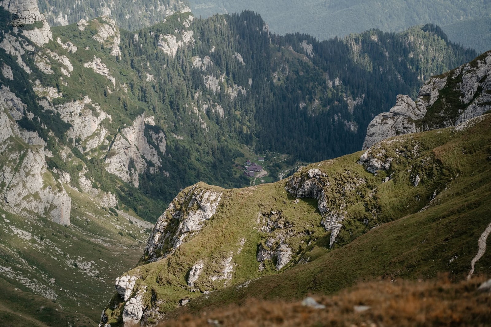 Cabana Mălăiești văzută de sus, în mijlocul văii glaciare, între versanți stâncoși și păduri